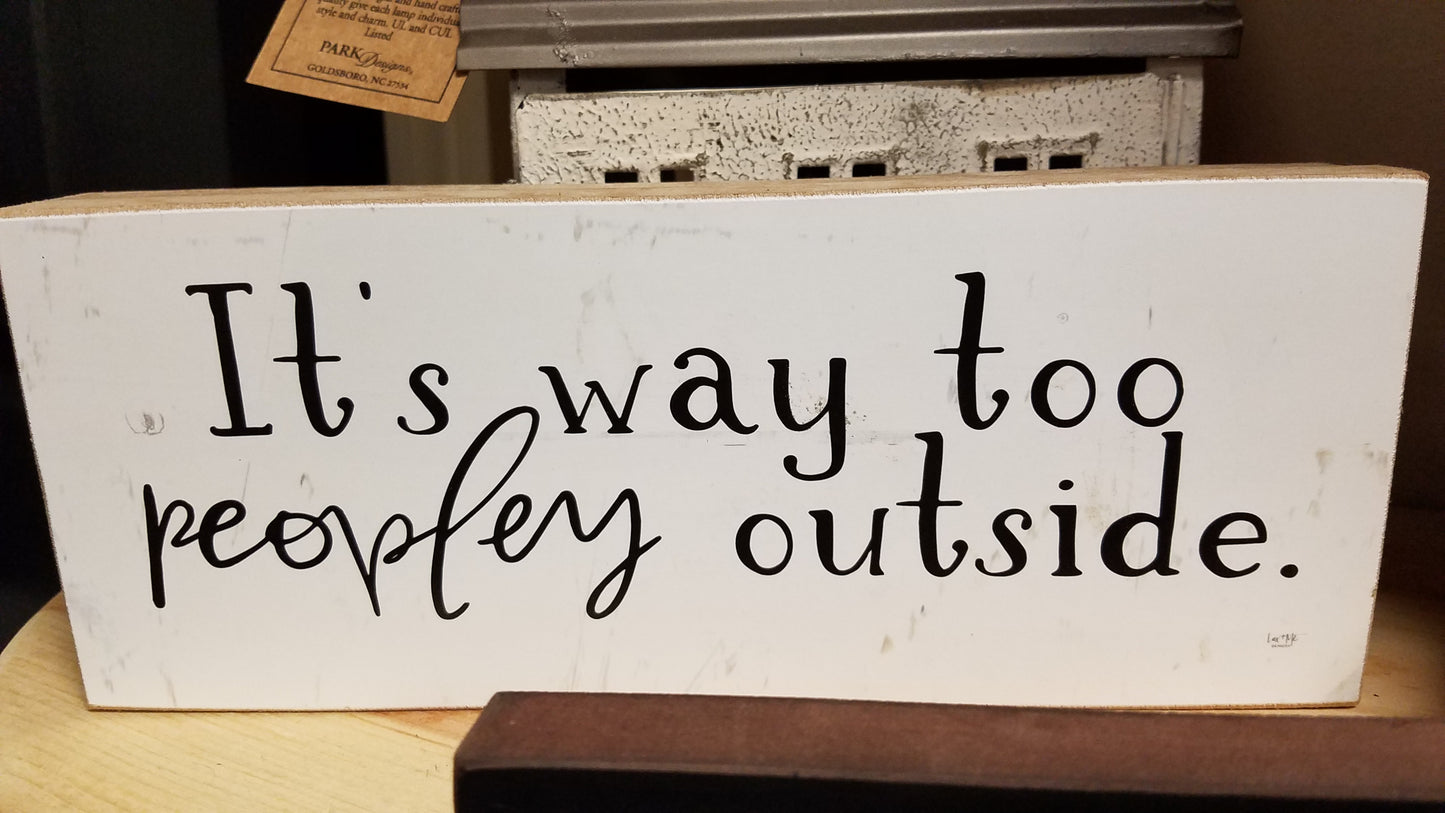 White background and black letters that read, "It's way too peopley outside". On piece of wood