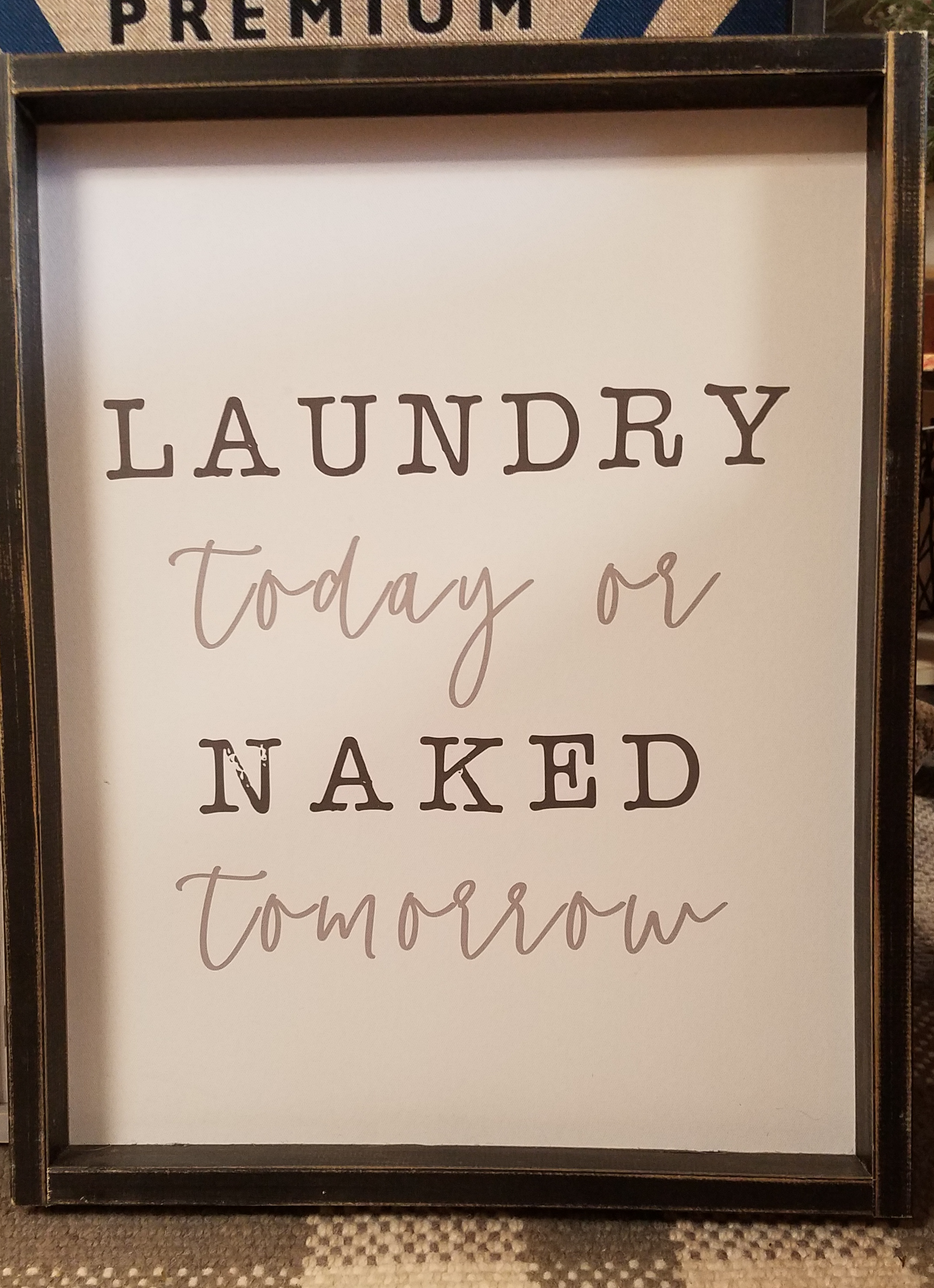 Rustic tobacco lath frame around white sign that reads "Laundry Today or Naked Tomorrow"