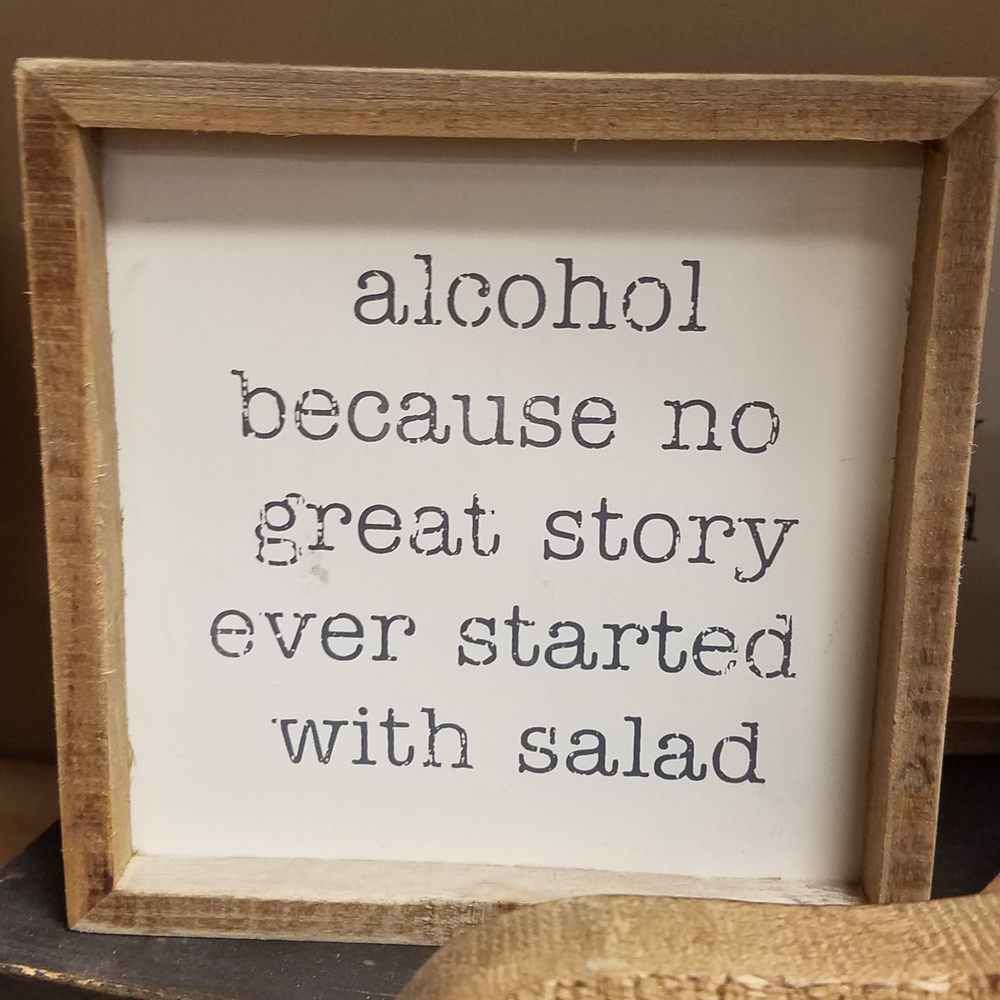 weathered wooden frame designed for rustic look with inset sign featuring funny text that reads "alcohol because no great story ever started with a salad