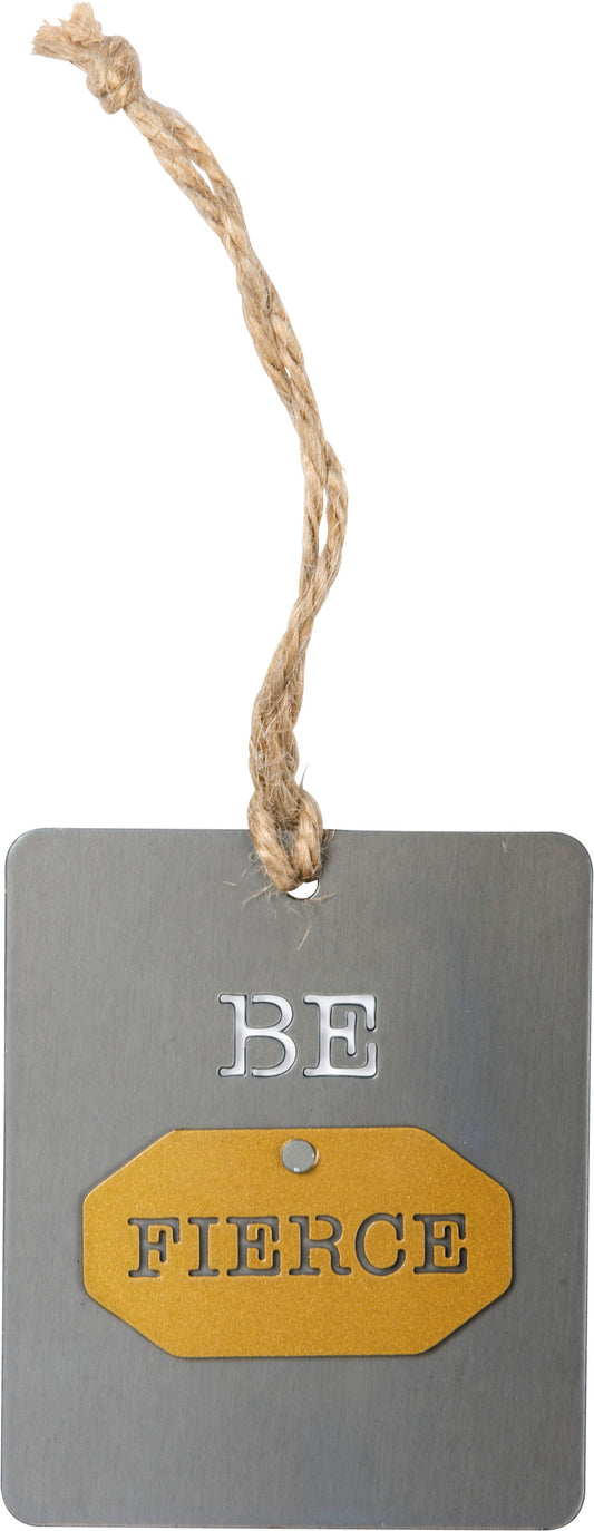 A metal ornament lending a "Be Fierce" sentiment. Features riveted dimensional accent and jute string attachment for easy hanging