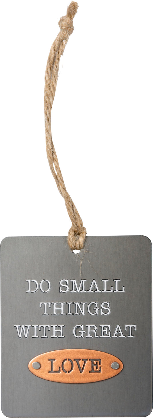 A metal ornament lending a "Do Small Things With Great Love" sentiment. Features riveted dimensional accent and jute string attachment for easy hanging. Great for gifting!