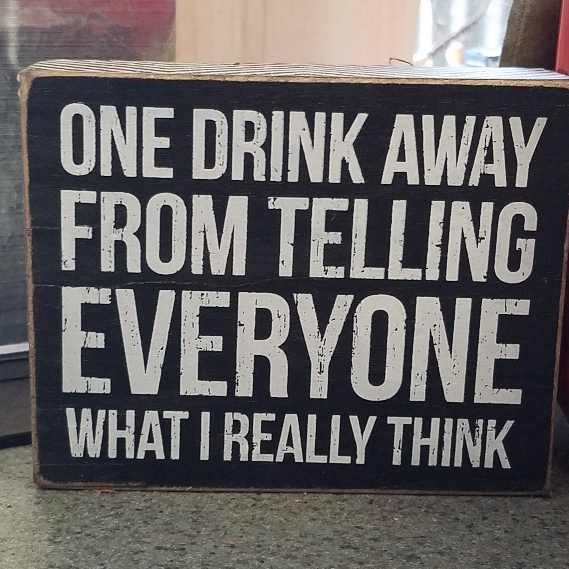 Black and white wooden box sign featuring a distressed inch One Drink Away from telling everyone what I really think" sentiment. Measures 5 x 4-inches. 