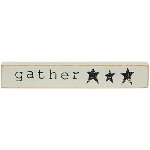 Live Simply Mini Stick is a wooden quote stick that comes in three assorted designs. Each stick reads, "gather," "bless our home," or, "live simply" and is accented with farmhouse illustrations like five-point stars, a crow, and a windmill. Stick has a flat bottom for shelf or tabletop display and measures 1" high by 6" wide.