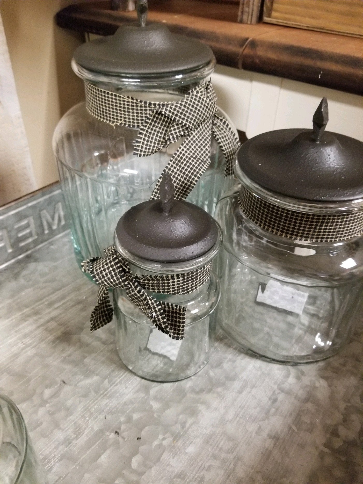 3 Glass jars with black metal cover with star on top for character. also ribbon tied around the neck as an accent that make it pop