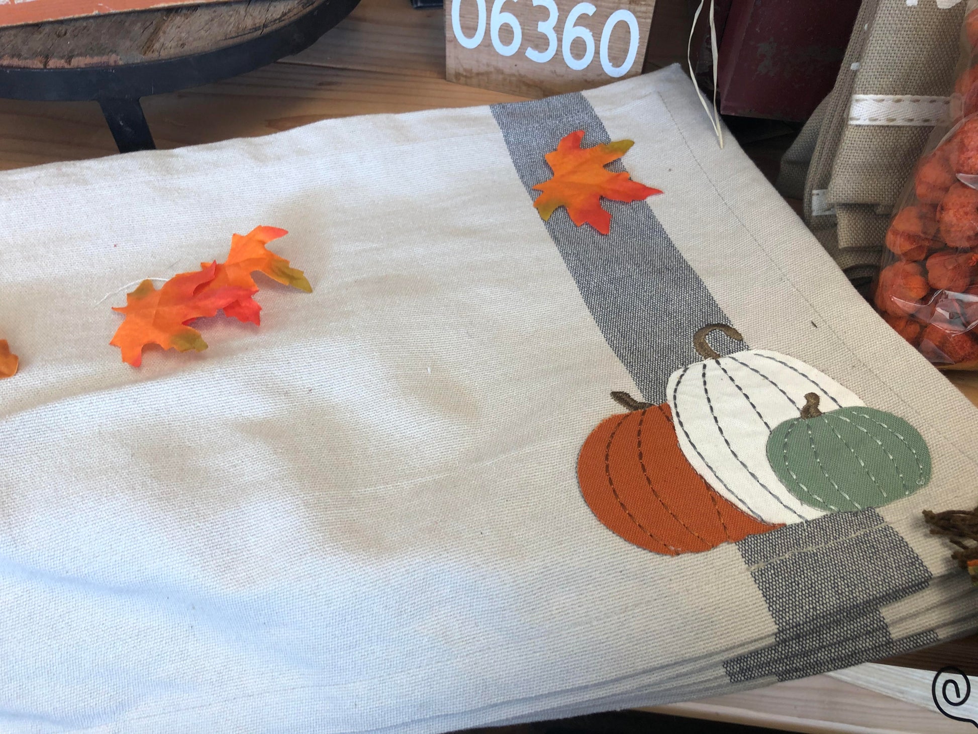 Fall placemat with strip on one end and image of 3 small pumpkins accents of gray and cream to traditional fall colors for a fresh take on the season